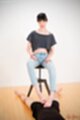 Sitting on stool looking down wearing jeans giving footjob bare feet